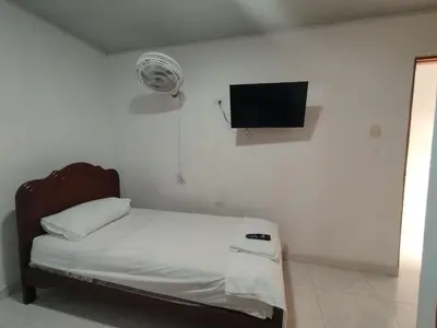 a bedroom with a bed and a tv on the wall at Casa Turistica Parador Verona in Cartagena de Indias