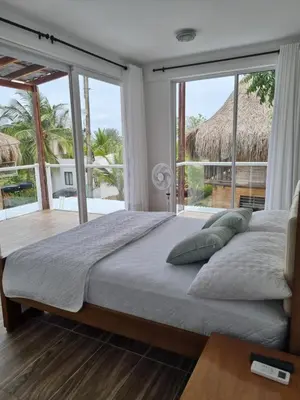 a bedroom with a large bed with a large window at HELENA Beach House in La Rada
