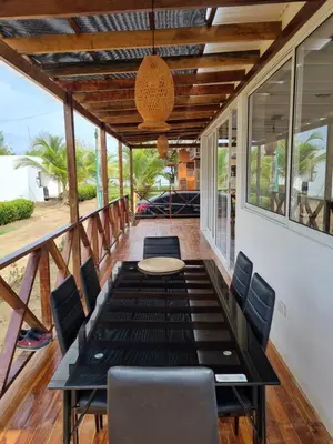 a screened in porch with a table and chairs at HELENA Beach House in La Rada
