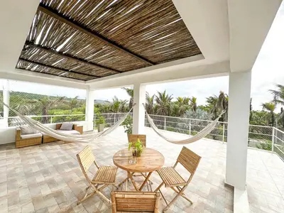 a patio with a hammock and a table and chairs at Apartment for 8 Guests in Sabanilla a few steps from the Sea in Maizal