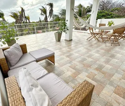 a patio with a couch and chairs and a hammock at Apartment for 8 Guests in Sabanilla a few steps from the Sea in Maizal