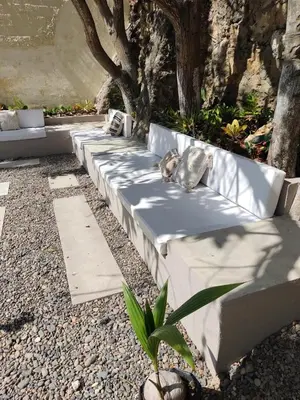 a row of white benches with pillows on them at Apartment for 8 Guests in Sabanilla a few steps from the Sea in Maizal