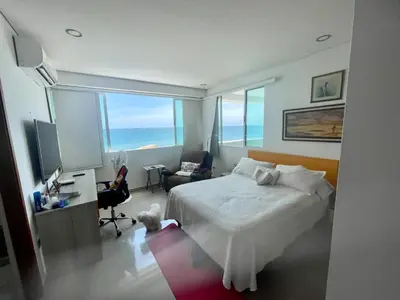 a bedroom with a bed and a desk with a computer at Cartagena Excelente Apartamento in Cartagena de Indias