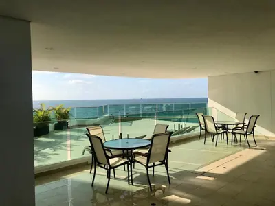 a balcony with tables and chairs and a view of the ocean at Cartagena Excelente Apartamento in Cartagena de Indias