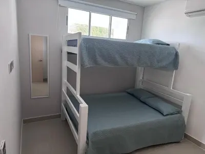 a bedroom with two bunk beds and a mirror at Apartamentos Mi Reserva OK - Arrecife in Coveñas