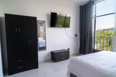 a bedroom with a bed and a tv on the wall at Cartagena Apartamento in Cartagena de Indias