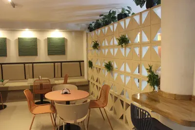 a restaurant with tables and chairs and a wall with plants at Hotel Fontamar 72 in Barranquilla