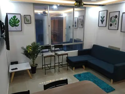 a living room with a blue couch and a table at Espectacular apartamento amoblado en BARRANQUILLA in Barranquilla