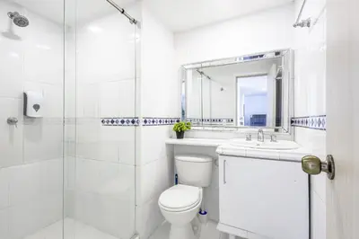 a white bathroom with a toilet and a sink at Riviera Coral Beach - Con vista al mar in Cartagena de Indias