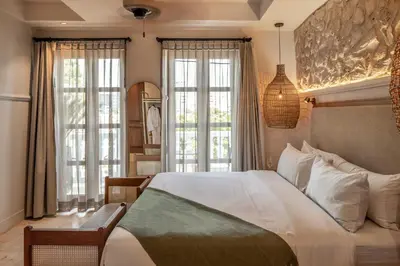 a bedroom with a large bed and two windows at Hotel Casa Sonara in Cartagena de Indias