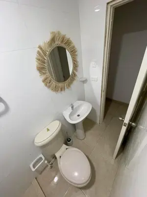 a bathroom with a toilet and a sink and a mirror at Apartment near the beach and airport in Cartagena de Indias