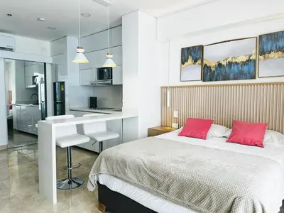 a bedroom with a large bed and a kitchen at Amazing loft - 2 minutes from the airport! in Cartagena de Indias