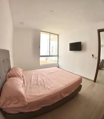 a bedroom with a bed and a tv on the wall at Hermoso apartamento serena del mar #1 in Puerto Tierrabaja