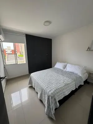 a bedroom with a bed with a blanket and a window at Apartamento diagonal a bv norte in Barranquilla