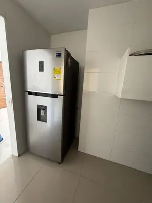 a white refrigerator in a room with a wall at Apartamento diagonal a bv norte in Barranquilla