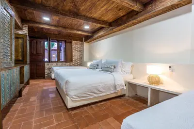 a bedroom with two beds and a table and a bed at Casa D Boutique in Cartagena de Indias