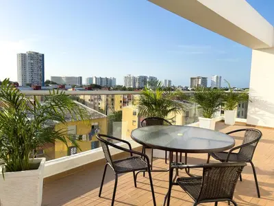 a patio with a table and chairs on a balcony at 2 cuartos terraza piscina AC in Cartagena de Indias