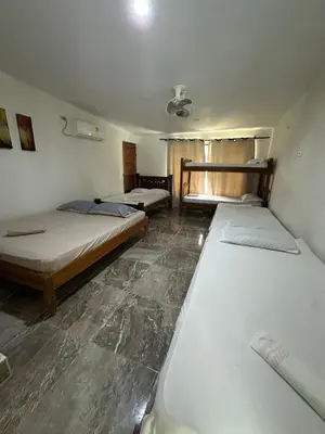 a room with three beds in it at Casa Blanca in Coveñas