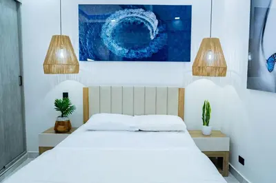 a bedroom with a white bed with two potted plants at Luxury Apartment BayView Jacuzzi Guestfriendly in Cartagena de Indias