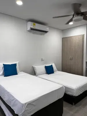 two beds in a room with two blue pillows at Apt luxury wifi AC pool at Cartagena in Cartagena de Indias