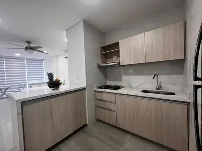 a kitchen with wooden cabinets and a sink at Apt luxury wifi AC pool at Cartagena in Cartagena de Indias