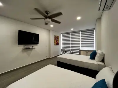 a bedroom with two beds and a flat screen tv at Apt luxury wifi AC pool at Cartagena in Cartagena de Indias