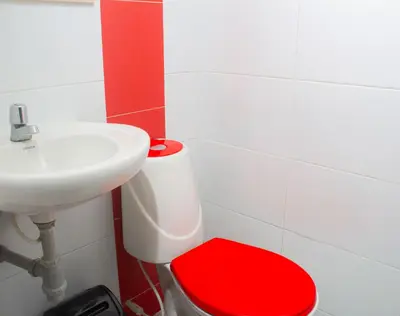 a bathroom with a red toilet and a sink at Hotel Catedral inn B SAS in Barranquilla