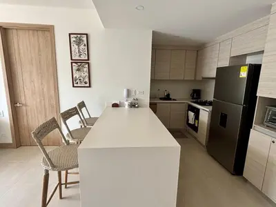 a kitchen with a white counter and a black refrigerator at Beachfront Stay Morros EOS in Cartagena de Indias