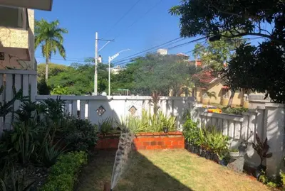 a backyard with a white fence and some plants at Apartamento de lujo alto prado in Barranquilla