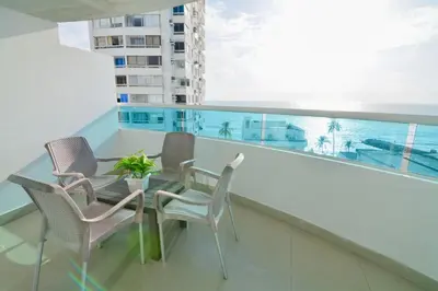 a balcony with chairs and a table with a view of the ocean at Alojamiento en Torres del Lago in Cartagena de Indias