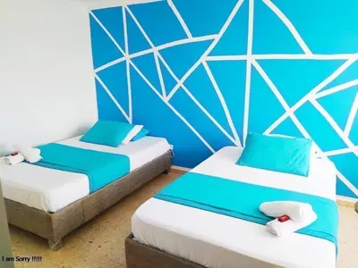 two beds in a room with blue walls at alojamiento frente mar 11 in Cartagena de Indias