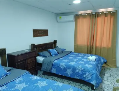 a bedroom with two beds and a dresser at Bogavante Getsemani para familias in Cartagena de Indias