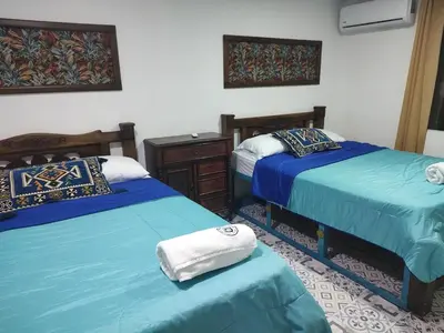 a bedroom with two beds with blue sheets and a dresser at Bogavante Getsemani para familias in Cartagena de Indias