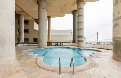 a large swimming pool in a building with columns at Hermoso Apto Frente Al Mar in Cartagena de Indias