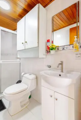 a white bathroom with a toilet and a sink at Hermoso Apto Frente Al Mar in Cartagena de Indias