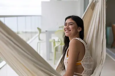 a woman is smiling while standing in a hammock at Clifford Place Morros epic - Direct Beach Access in Cartagena de Indias