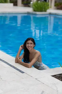 a woman laying on the side of a swimming pool at Clifford Place Morros epic - Direct Beach Access in Cartagena de Indias