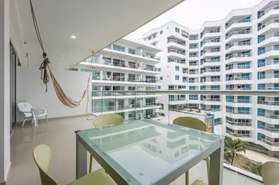 a room with a glass table in front of a large building at Clifford Place Morros epic - Direct Beach Access in Cartagena de Indias