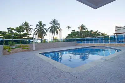 a swimming pool in a courtyard with palm trees at Riviera del Mar - Apartamento con vista panorámica al mar in Cartagena de Indias