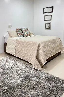 a bedroom with a large bed with a rug at aparta estudio susheria in Sincelejo