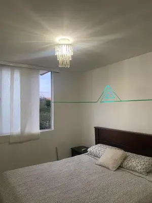 a bedroom with a bed with a chandelier and a window at Playa Azul in Puerto Colombia