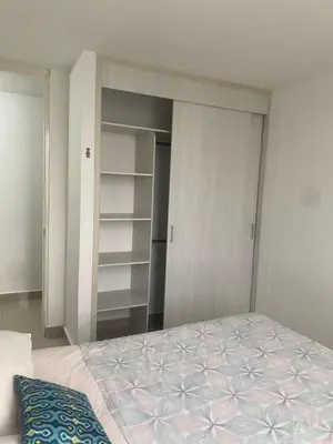 a bedroom with a bed and an open closet at Playa Azul in Puerto Colombia