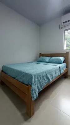 a bed with a wooden frame in a bedroom at Hostal berpé in Coveñas