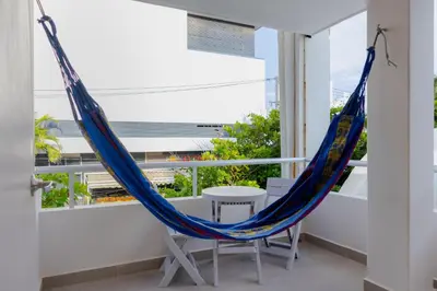 a hammock on the balcony of a house at New Pueblito Suites - Cerca a la Playa in Cartagena de Indias