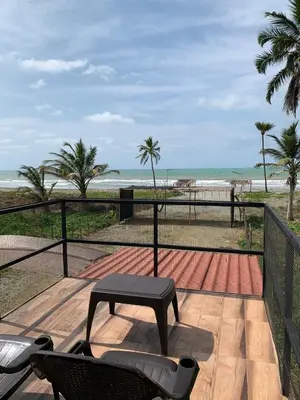 a patio with a table and chairs and the beach at Hostal pura vida in San Bernardo del Viento