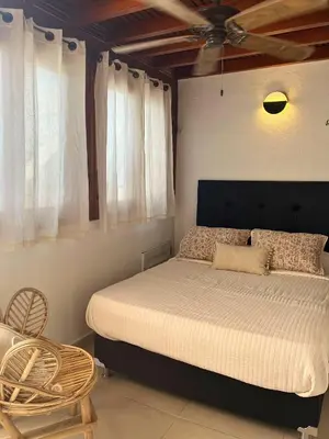 a bedroom with a bed and a chair at Duplex con Piscina privada en Centro Histórico in Cartagena de Indias