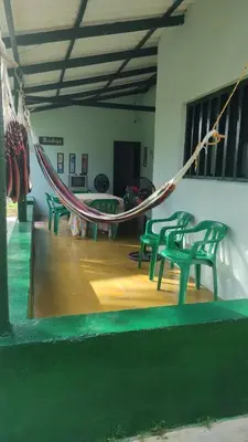 a hammock in a room with four green chairs at Tundsya in San Antero