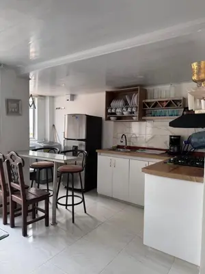 a kitchen with white cabinets and bar stools at Apartamento Caribe Coveñas 102 in Coveñas