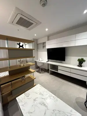a living room with a large television and a desk at Apto 305 Distrito 90 in Barranquilla