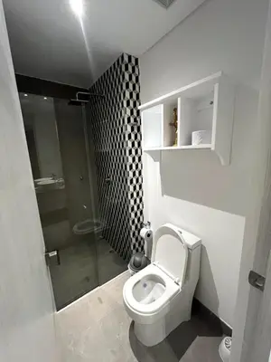 a white bathroom with a toilet and a shower at Apto 305 Distrito 90 in Barranquilla